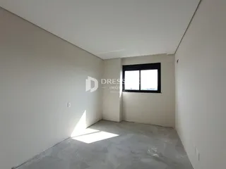 Foto de um cômodo interno com paredes brancas e piso de concreto.