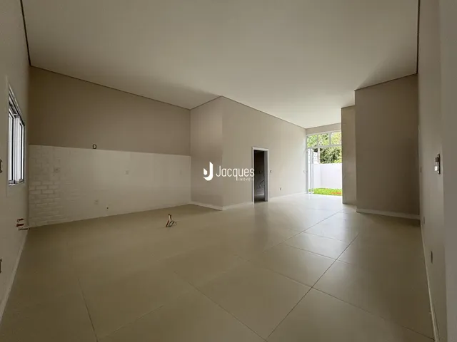 Vista ampla de um ambiente interno com paredes brancas e piso claro.