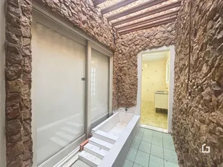Hall com paredes de pedra e uma porta de entrada.