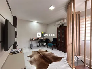 Sala de estar com piso claro e móveis de madeira na área interna.