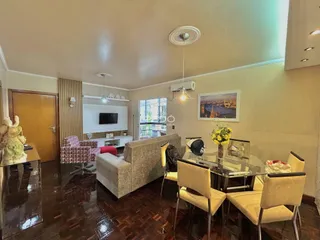 Sala de estar com piso de madeira e móveis.