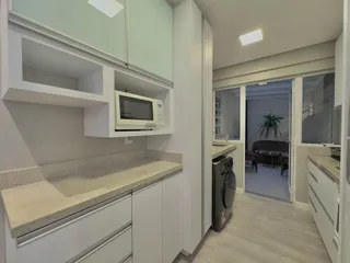 Foto de uma cozinha moderna com armários brancos e bancadas claras.