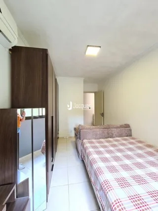 Quarto com cama e painel de madeira em uma residência.