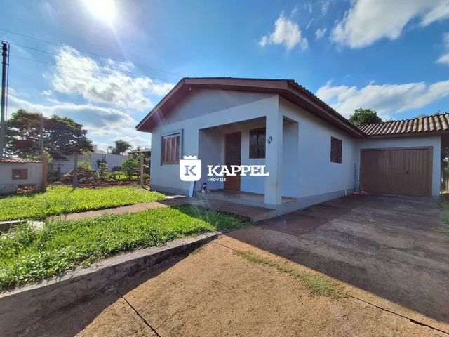 Fachada de uma casa simples em Lajeado, Brasil, com jardim e garagem.