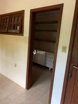 Vista de um corredor interno com portas de madeira e um nicho de armário.