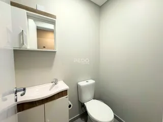 Banheiro moderno com bancada e vaso sanitário em um imóvel.