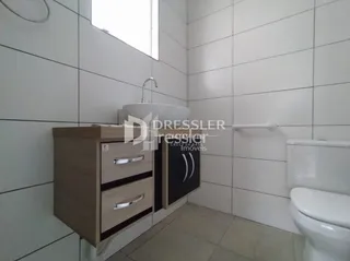 Um banheiro com revestimento cerâmico e louças brancas.
