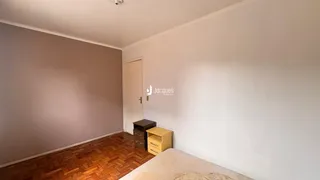 Uma sala com piso de madeira e parede branca.