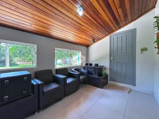 Sala de estar com piso de cerâmica e teto de madeira no imóvel.