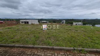Vista de um terreno gramado com edificações ao fundo.