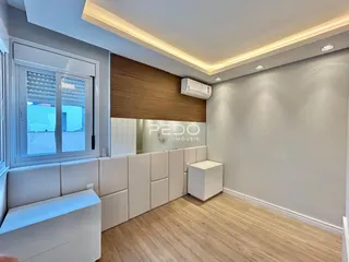 Sala de estar moderna com piso de madeira e paredes cinzas.