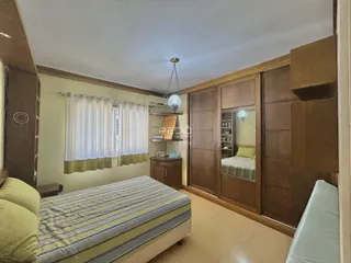 Quarto com paredes de madeira e armários embutidos.
