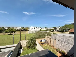 Uma vista panorâmica de campos verdes e paisagem sob um céu azul.