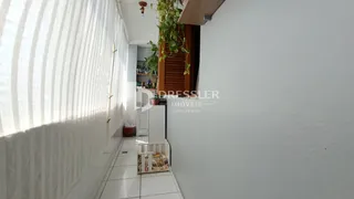 Corredor interno de uma residência com paredes brancas e piso de cerâmica.
