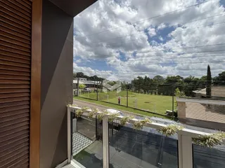 Vista externa de um campo gramado com cerca ao fundo da propriedade.