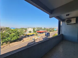 Vista da propriedade com paisagem urbana e vegetação ao fundo.