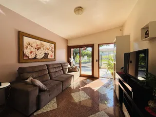 Sala de estar com sofá e piso de cerâmica em uma residência.