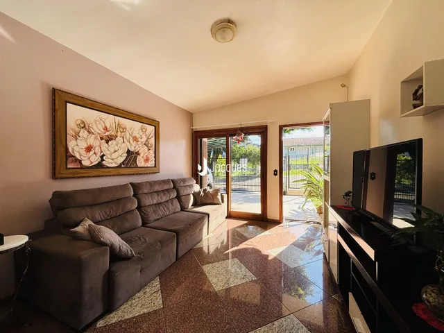 Sala de estar com sofá e piso de cerâmica em uma residência.