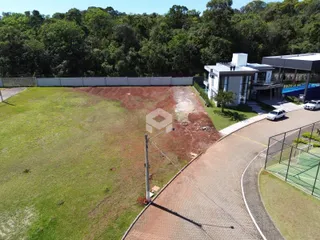 Vista externa da propriedade com gramado e área de acesso ao imóvel.