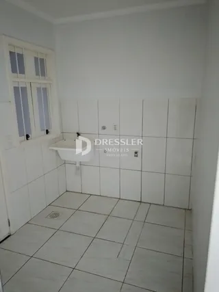 A foto mostra o interior de um banheiro com revestimento de azulejos brancos.