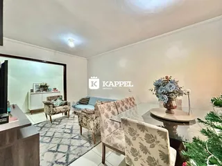 Uma sala de estar com sofá e poltronas decoradas em um imóvel em Lajeado.