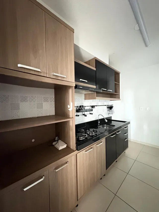 Cozinha moderna com armários de madeira e bancada preta.