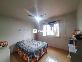 Quarto com cama coberta e janela.