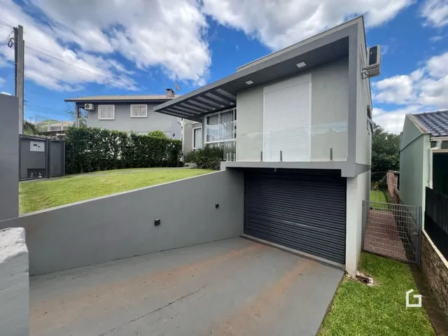 Fachada de uma casa moderna com garagem e quintal em Lajeado, Brasil.