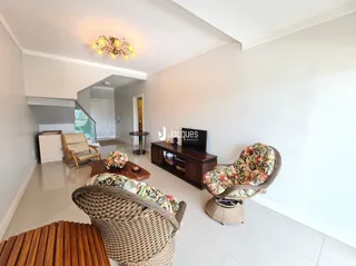 Sala de estar com móveis de vime e piso claro.