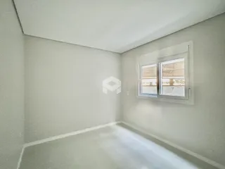 Foto de um cômodo interno com paredes claras e uma janela.