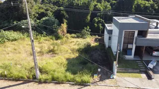 Vista externa de uma residência com vegetação densa ao redor.