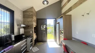 Interior de uma sala de estar com cozinha e área de jantar em um imóvel no Brasil.