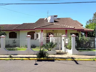 Fachada de uma casa residencial em Lajeado, Brasil com cerca branca e portão de ferro.