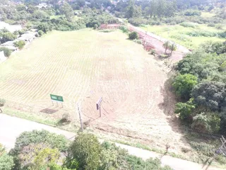 Vista aérea de uma grande área de terra com vegetação e um rio no primeiro plano.