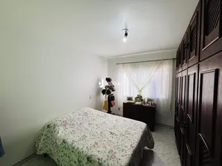 Quarto com cama e armário de madeira no interior da residência.