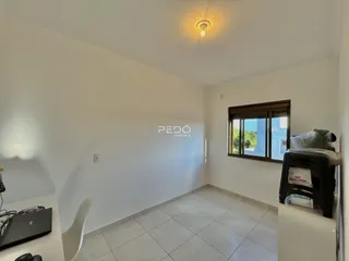 Interior de uma sala com piso de cerâmica e paredes brancas.