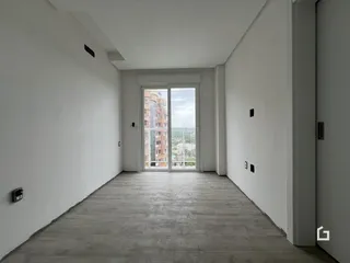 Corredor interno com piso de concreto e vista para a paisagem urbana.