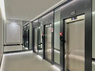 Vista do corredor de um prédio com elevadores.