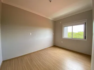 Foto de um cômodo interno com paredes claras e piso de madeira.