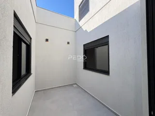 Vista interna de um espaço com paredes brancas e piso cinza claro.