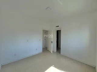 Vista interna de um ambiente com paredes brancas e piso claro.