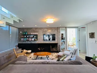 Sala de estar com lareira e sofá de cor neutra.