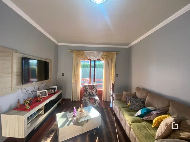 Sala de estar com sofá e televisão em um imóvel.