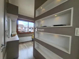 Hall de entrada com janela e piso de madeira em um imóvel.