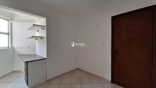 Corredor interno com paredes brancas e piso de cerâmica.