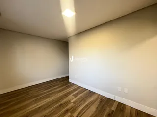 Foto de um ambiente interno com piso de madeira clara.