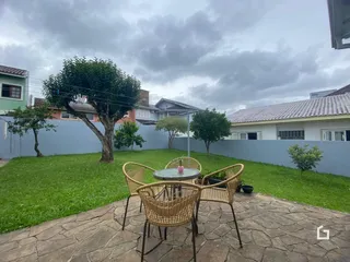 Vista do jardim com área de lazer e mobiliário externo.