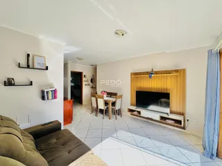 Sala de estar com sofá e área de jantar em um imóvel no Brasil.