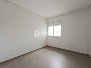 Foto de um ambiente interno vazio com paredes brancas e piso de cerâmica.