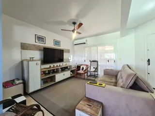 Sala de estar com sofá e rack de TV em ambiente interno.